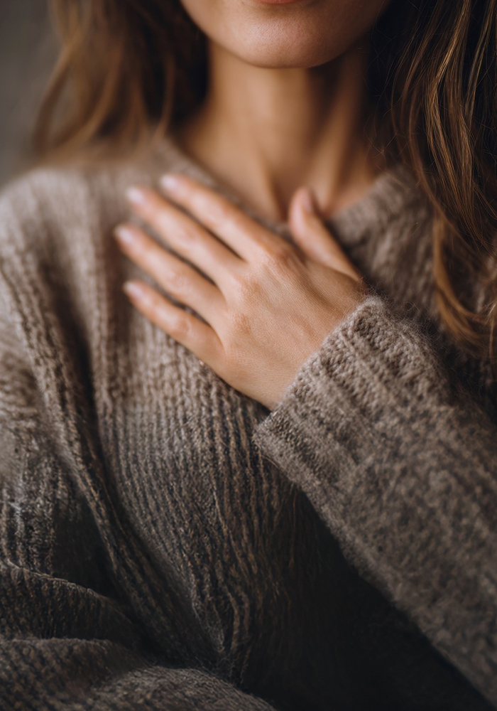 Counselling-self-care A women holding her hand to her chest in a calming way to show self care through counselling.